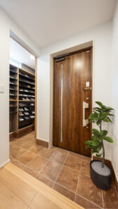 木目が映える玄関ドアと広々シューズクローク